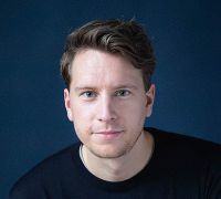 Headshot of a white young man on a navy background